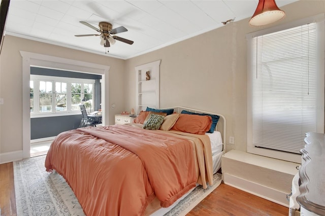 bedroom featuring crown molding, ceiling fan, and light wood-type flooring