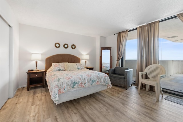 bedroom with a textured ceiling and light wood-type flooring