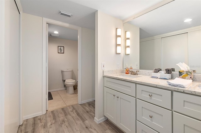 bathroom featuring hardwood / wood-style flooring, vanity, and toilet