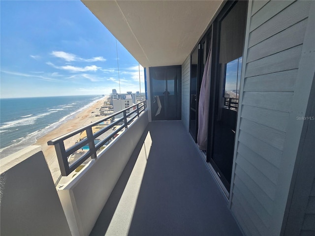 balcony featuring a water view and a view of the beach