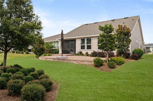 rear view of house with a sunroom, a yard, and a patio area