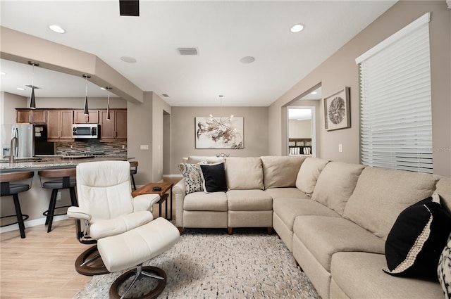 living room with sink and light hardwood / wood-style floors