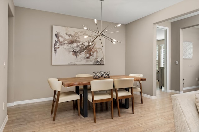 dining space with a notable chandelier and light wood-type flooring