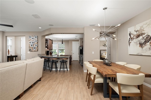 dining room featuring an inviting chandelier and light wood-type flooring