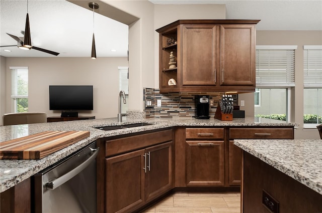 kitchen with tasteful backsplash, dishwasher, sink, ceiling fan, and light stone countertops