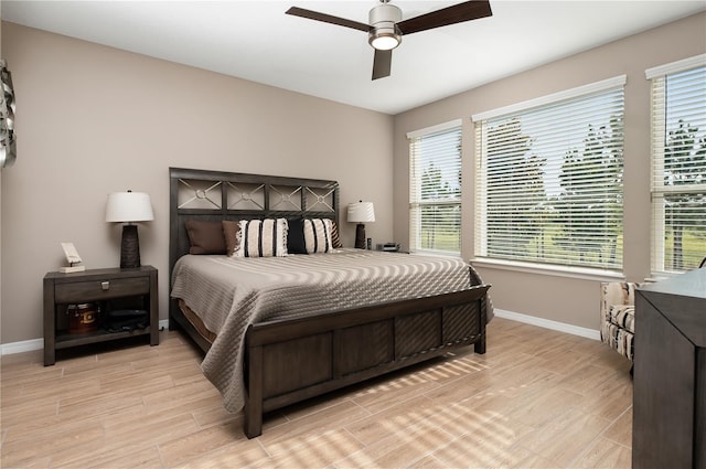 bedroom with multiple windows, ceiling fan, and light wood-type flooring