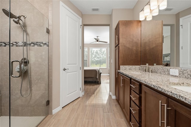 bathroom featuring vanity, a shower with door, and ceiling fan