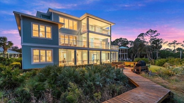 back house at dusk with a balcony