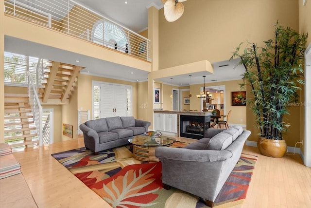 living room with ornamental molding, wood-type flooring, and a towering ceiling