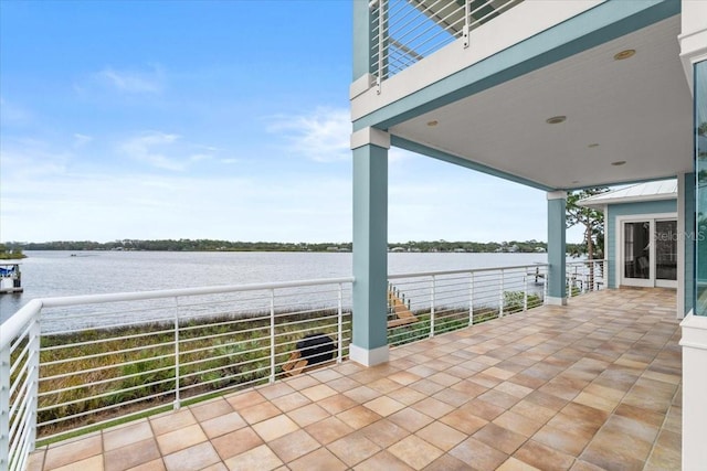 view of patio / terrace with a water view and a balcony