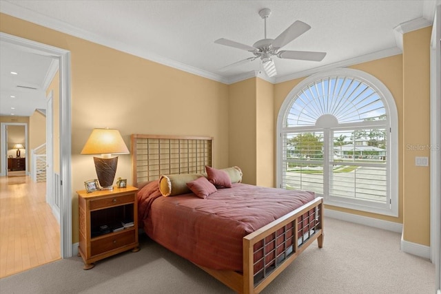 bedroom featuring ornamental molding, light carpet, and ceiling fan