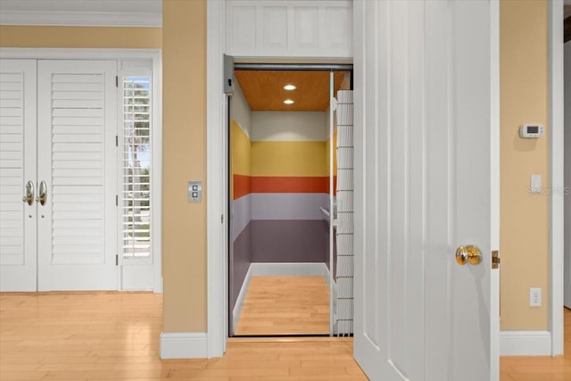 interior space featuring crown molding, light hardwood / wood-style flooring, and elevator