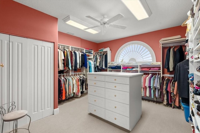 walk in closet featuring light colored carpet and ceiling fan