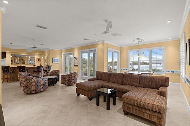 tiled living room with plenty of natural light, ornamental molding, and ceiling fan