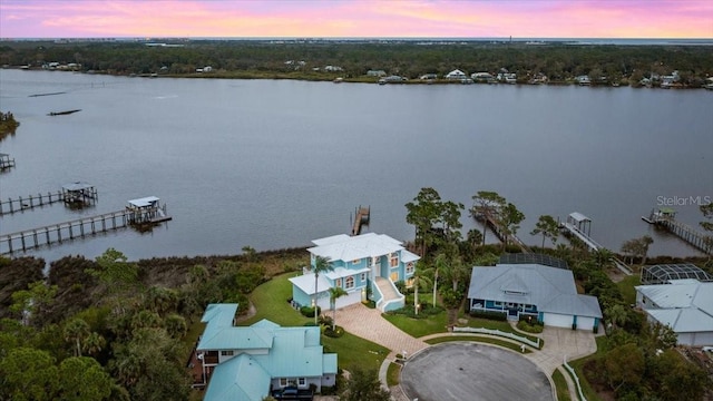 aerial view at dusk featuring a water view