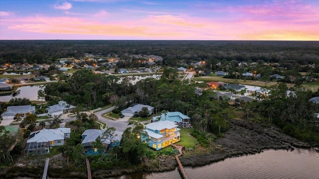 aerial view at dusk featuring a water view