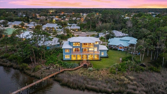 aerial view at dusk featuring a water view