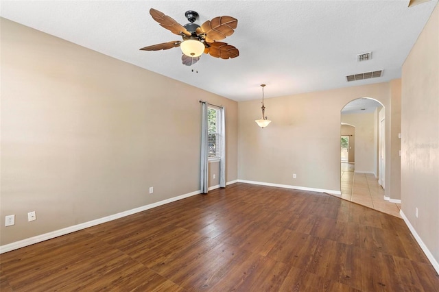 spare room with dark wood-type flooring and ceiling fan