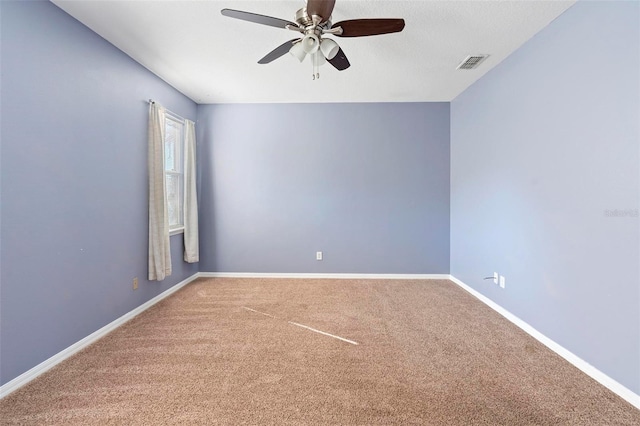 carpeted empty room with ceiling fan and a textured ceiling