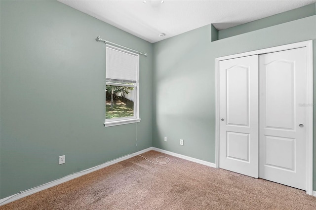 unfurnished bedroom with carpet flooring and a closet