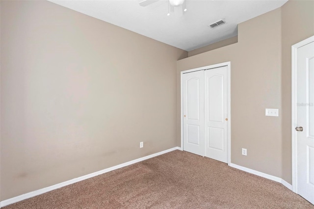 unfurnished bedroom with ceiling fan, carpet flooring, and a closet