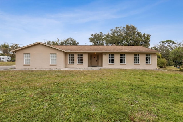 back of house featuring a yard and stucco siding