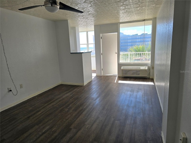 interior space with dark wood-type flooring, ceiling fan, a textured ceiling, and an AC wall unit