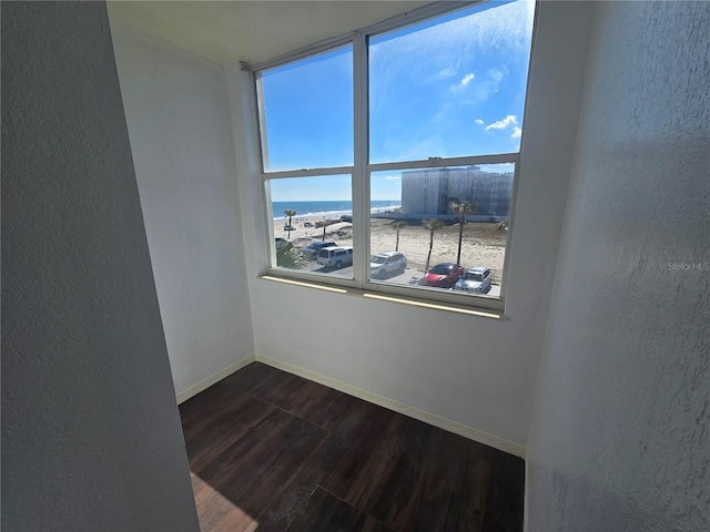 spare room featuring wood-type flooring and a water view