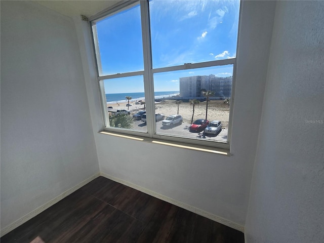 empty room with a water view and dark wood-type flooring