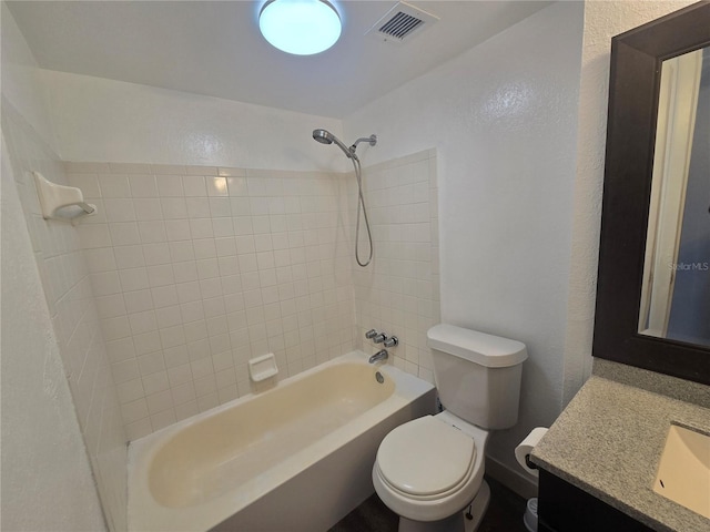 full bathroom featuring tiled shower / bath combo, vanity, and toilet