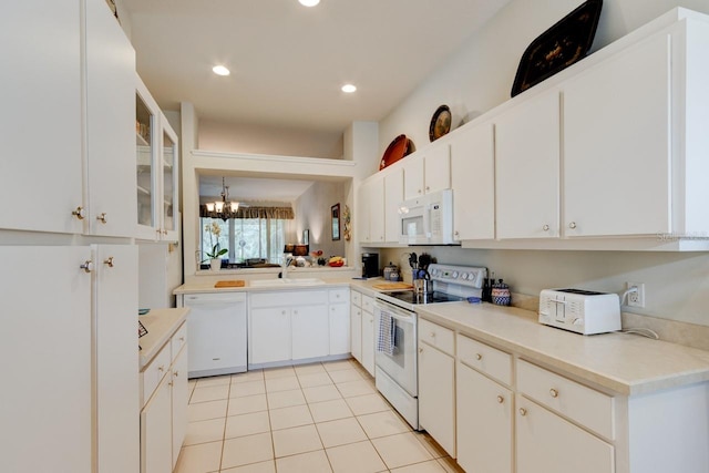 kitchen with white cabinetry, white appliances, light tile patterned flooring, and sink