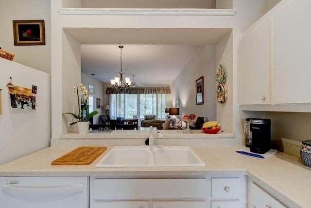 kitchen with dishwasher, sink, white cabinets, a chandelier, and hanging light fixtures