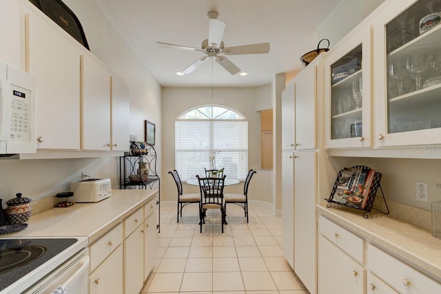 kitchen with ceiling fan, white appliances, white cabinets, and light tile patterned flooring