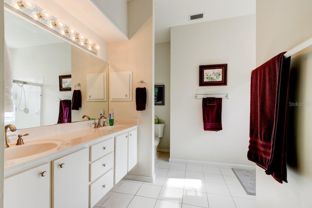 bathroom with vanity, tile patterned floors, toilet, and walk in shower