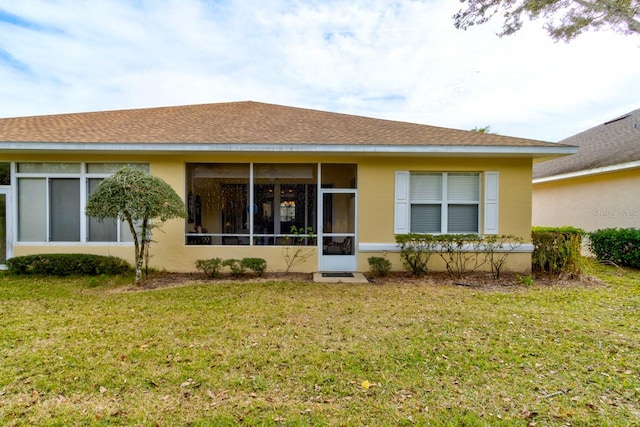 rear view of property featuring a lawn