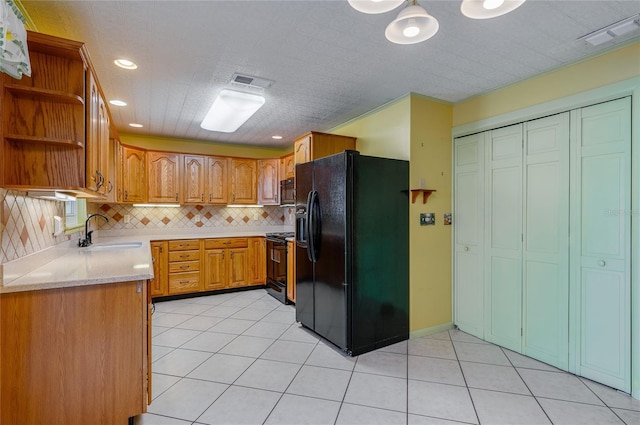 kitchen featuring sink, light tile patterned floors, tasteful backsplash, black appliances, and light stone countertops