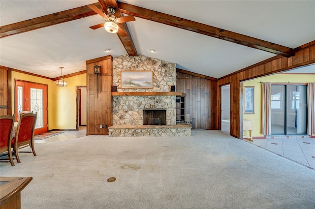 unfurnished living room with a stone fireplace, a healthy amount of sunlight, and light colored carpet