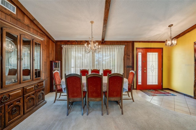 dining space featuring a healthy amount of sunlight, light carpet, and a chandelier