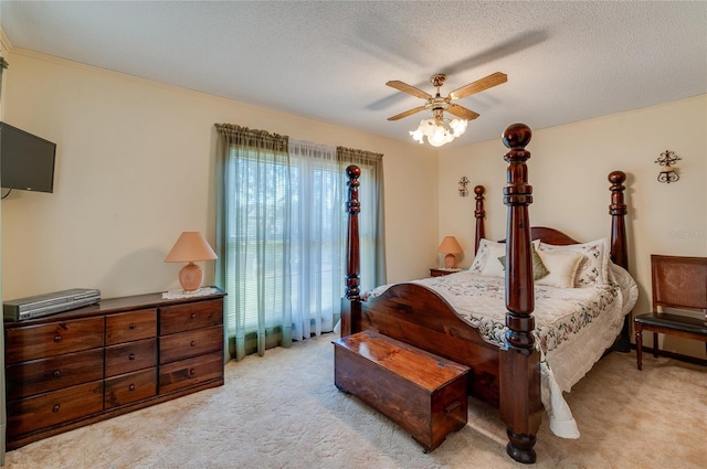 bedroom with ceiling fan, light carpet, and a textured ceiling