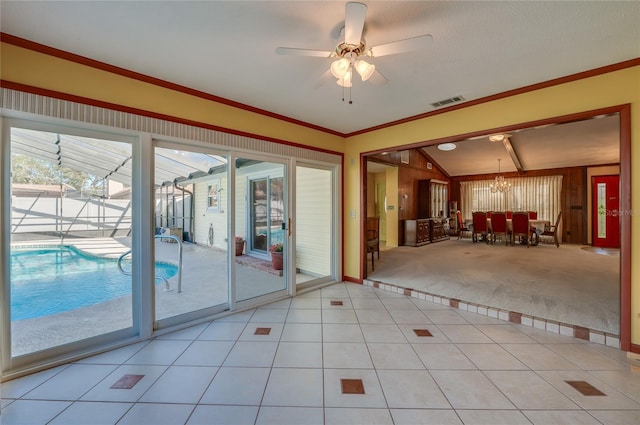 doorway to outside featuring crown molding, ceiling fan with notable chandelier, light tile patterned floors, and lofted ceiling