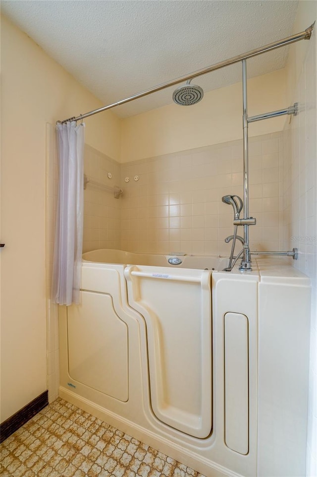 bathroom featuring curtained shower and a textured ceiling