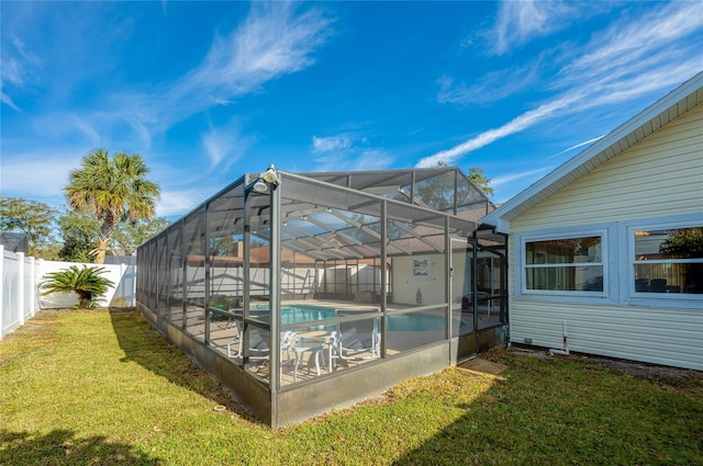 view of swimming pool featuring a lanai and a lawn