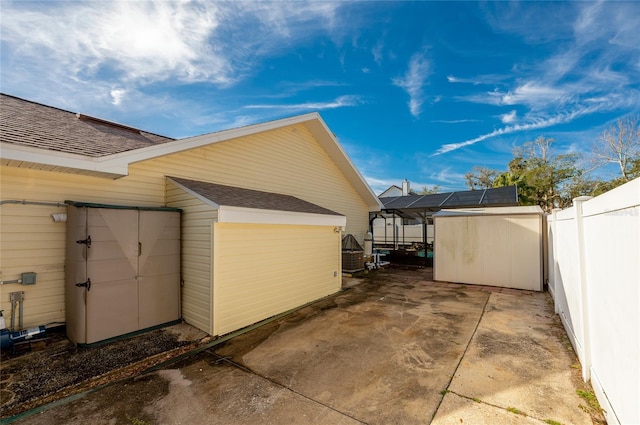 view of side of property with a storage shed and solar panels