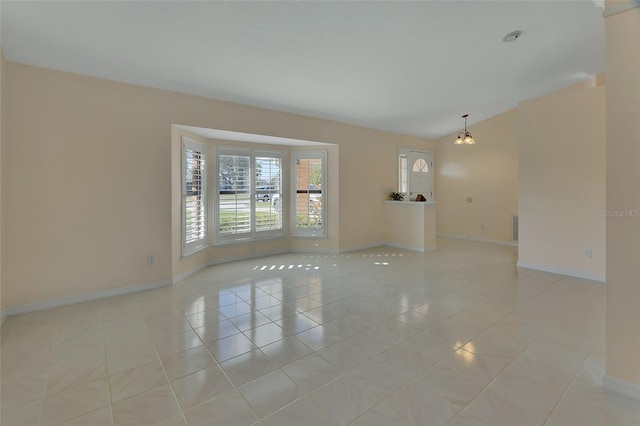 tiled spare room featuring lofted ceiling