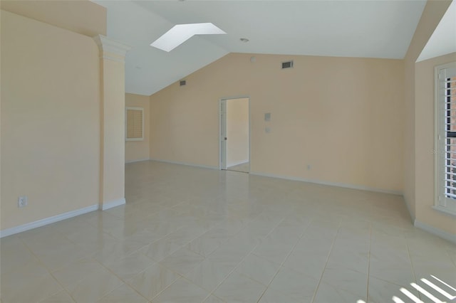 tiled spare room with vaulted ceiling with skylight