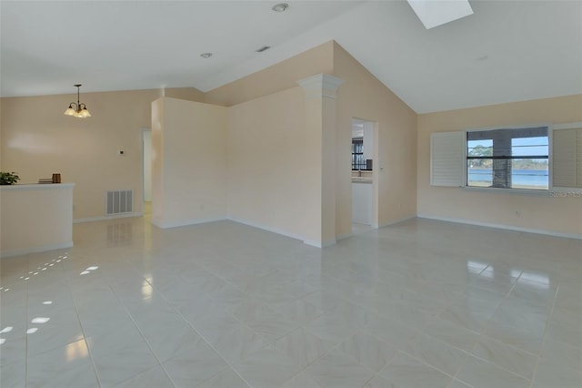 unfurnished living room with lofted ceiling with skylight and light tile patterned flooring