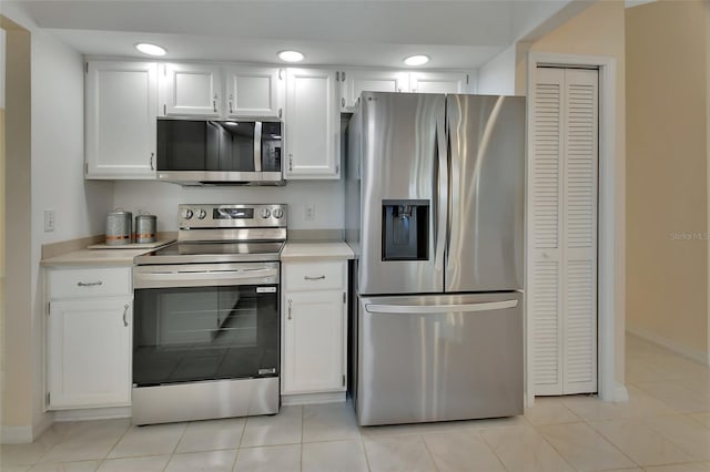 kitchen featuring white cabinetry, stainless steel appliances, and light tile patterned flooring