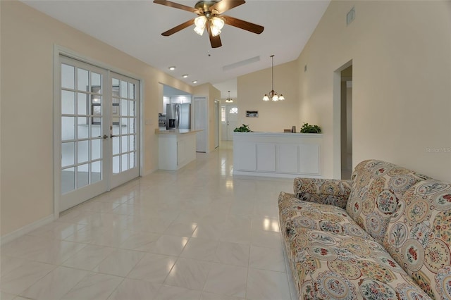 tiled living room with french doors, lofted ceiling, and ceiling fan with notable chandelier