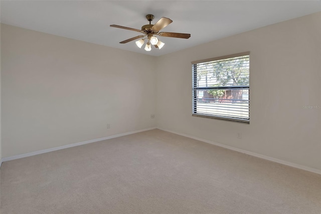 spare room featuring light carpet and ceiling fan