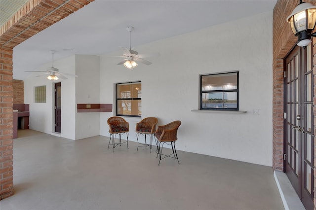 living area featuring concrete flooring, lofted ceiling, and ceiling fan